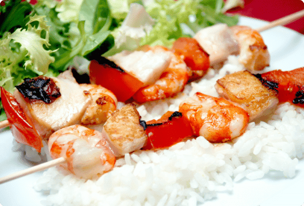 Brochetas de pescado con arroz de guarnición y ensalada