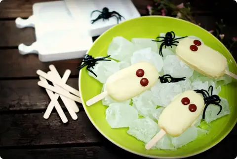 Helados fantasmas de Halloween con sabor a vainilla y cobertura de chocolate blanco