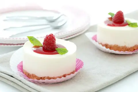 Tartitas individuales de crema cuajada de leche y queso con coul&iacute;s de frambuesas